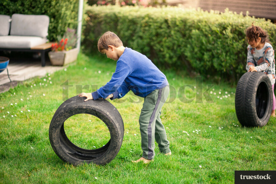 Young children playing with a tyre