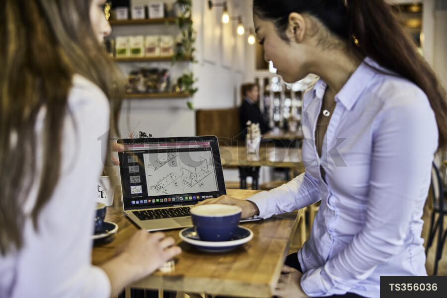 Remote coworkers working with laptop in cafe