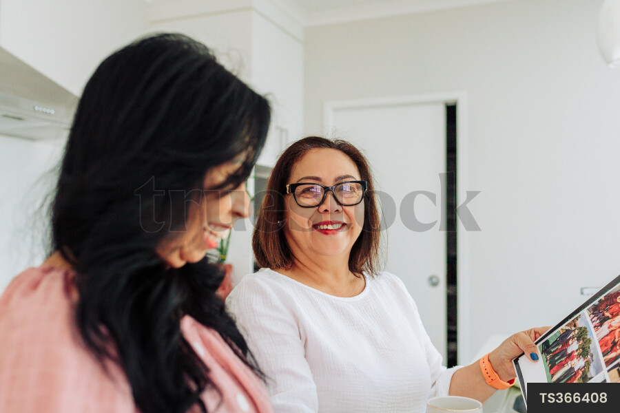 Women Looking at Book in Kitchen