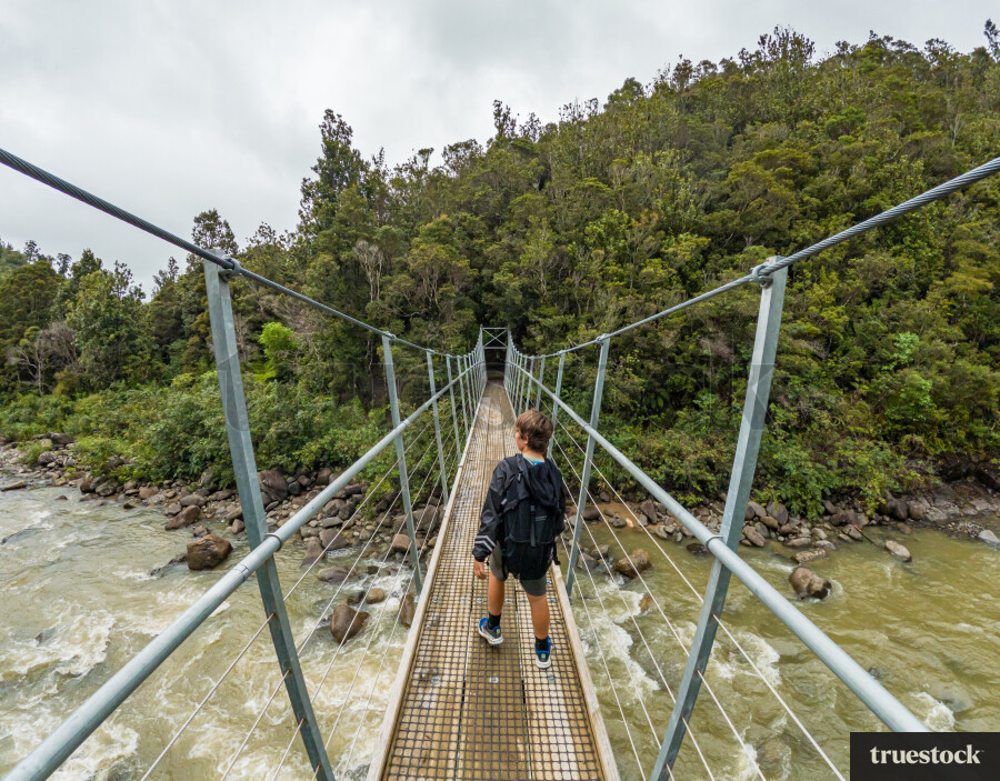 Young Boy Walking Across Bridge on Hike
