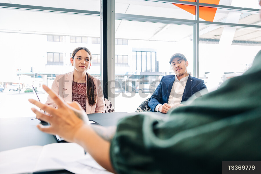 Businesspeople gesturing during meeting in boardroom