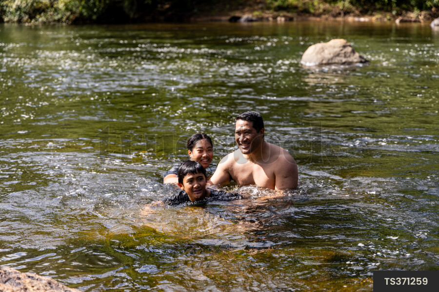 Family swimming in river