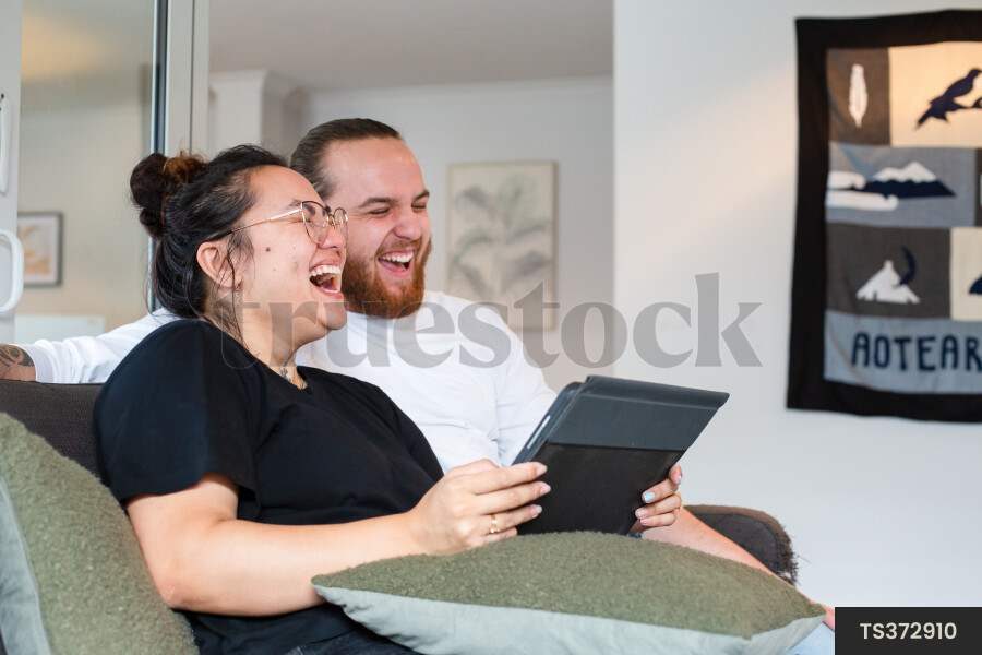 Couple Using iPad on Couch