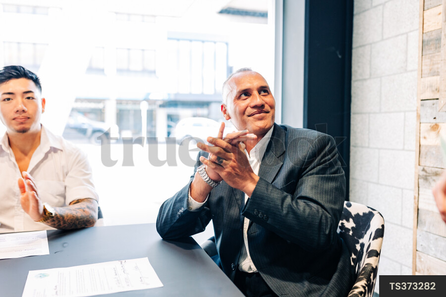 Businessmen clapping during meeting in boardroom