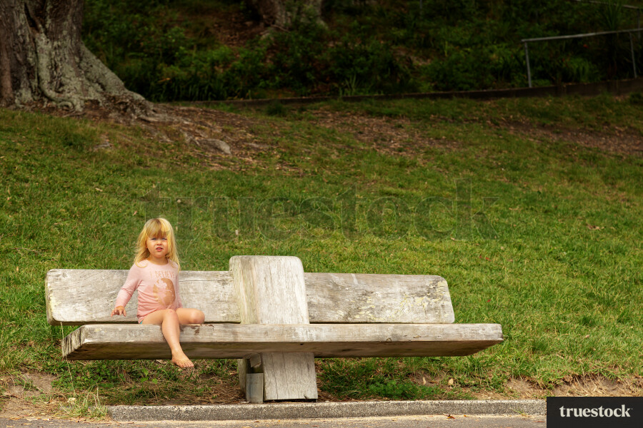 Girl Sitting on a Bench at the Beach