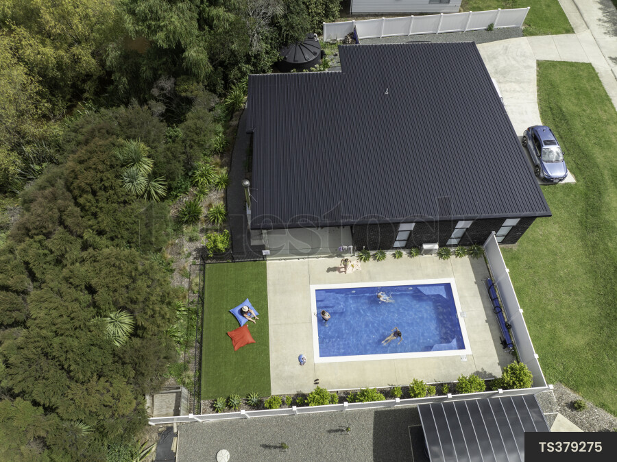 Drone view of family swimming in pool