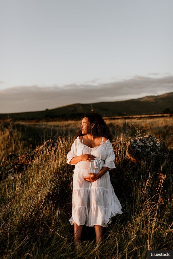 Woman Standing in Field for Maternity Shoot