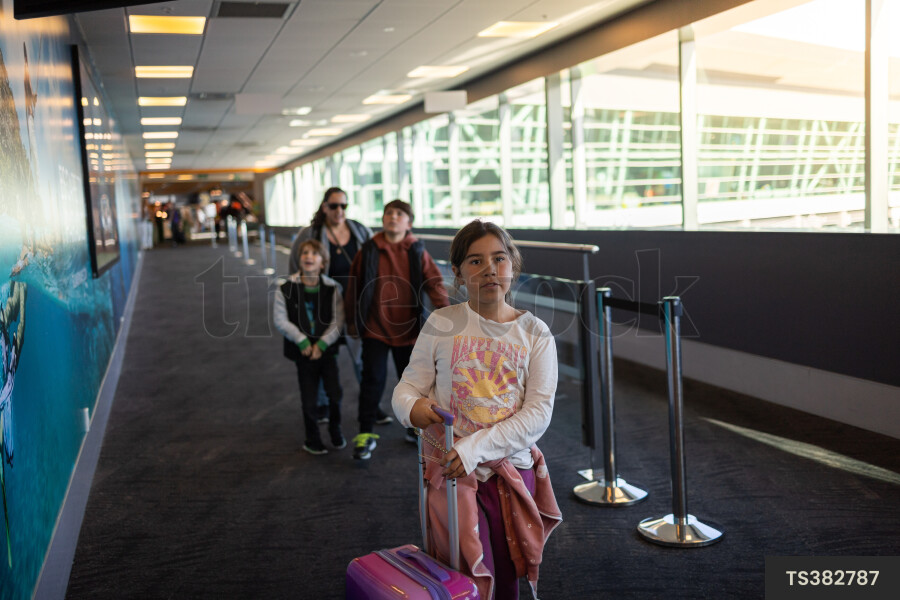 Girl walking with her family through Wellington Airport