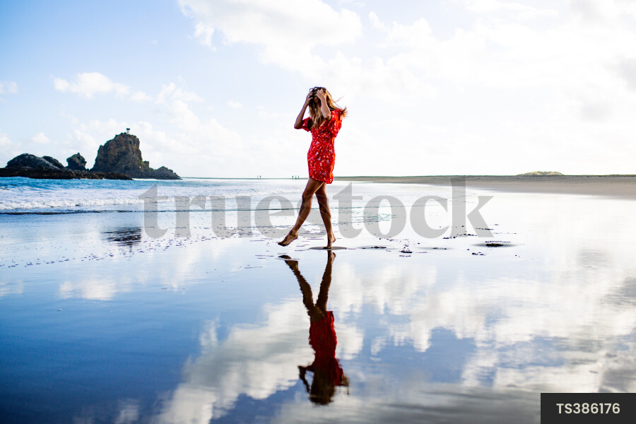 Woman on Whatipu Beach during sunset