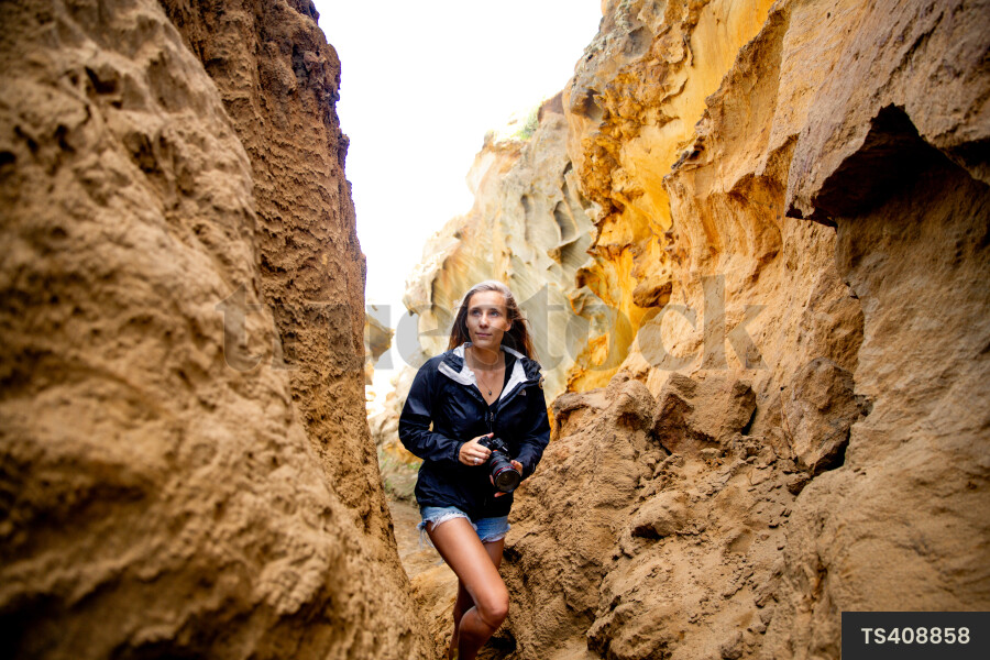 Woman with camera by cliffs