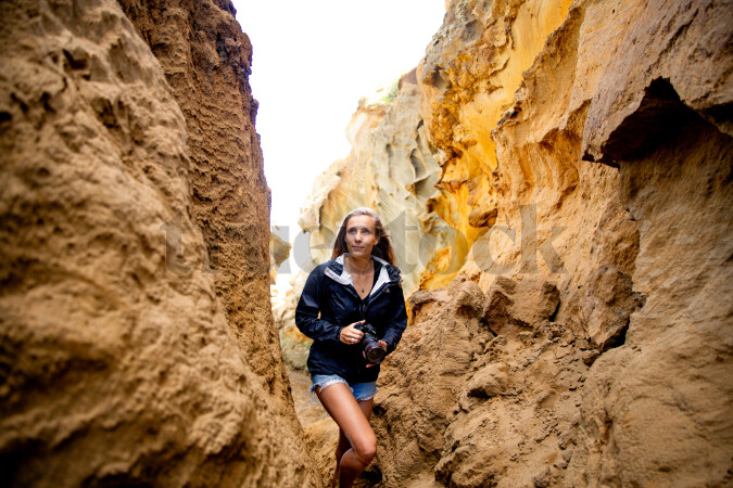 Woman with camera by cliffs