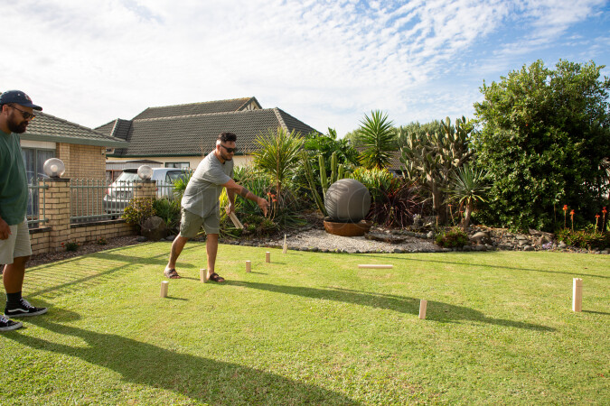 Friends playing kubb on lawn