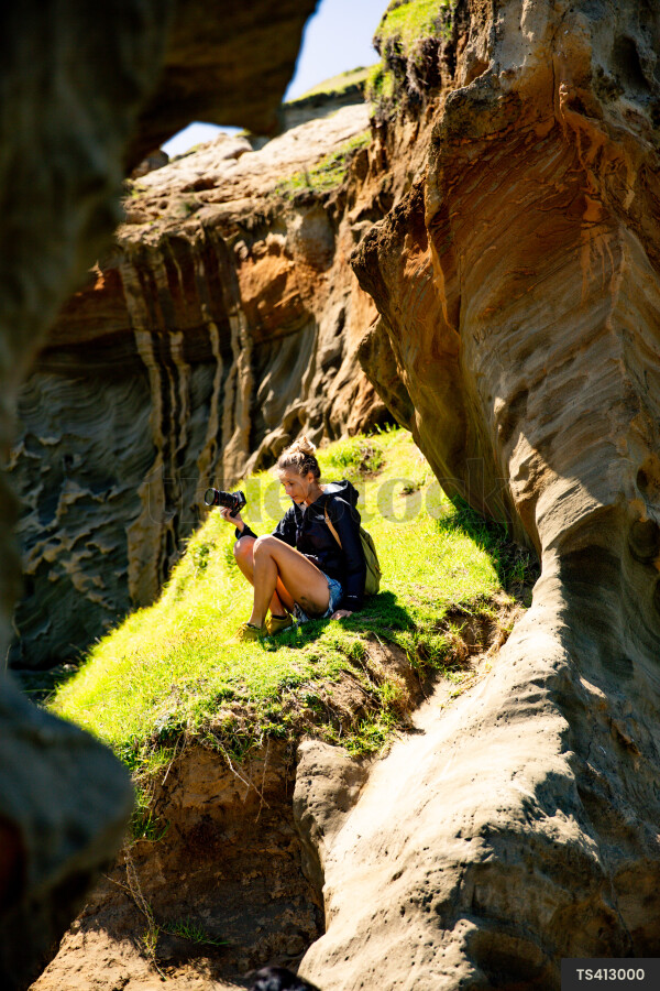 Woman with camera by cliffs