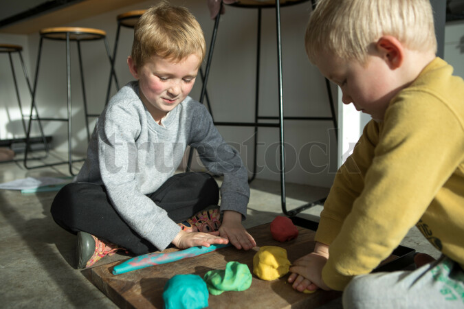 Children playing with playdough at home making shapes