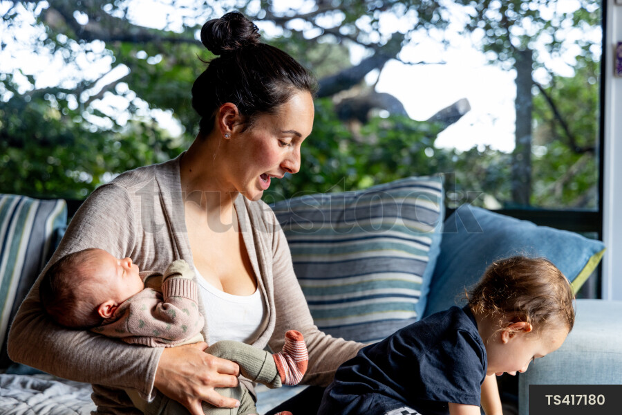 Mother and children talking on sofa in living room