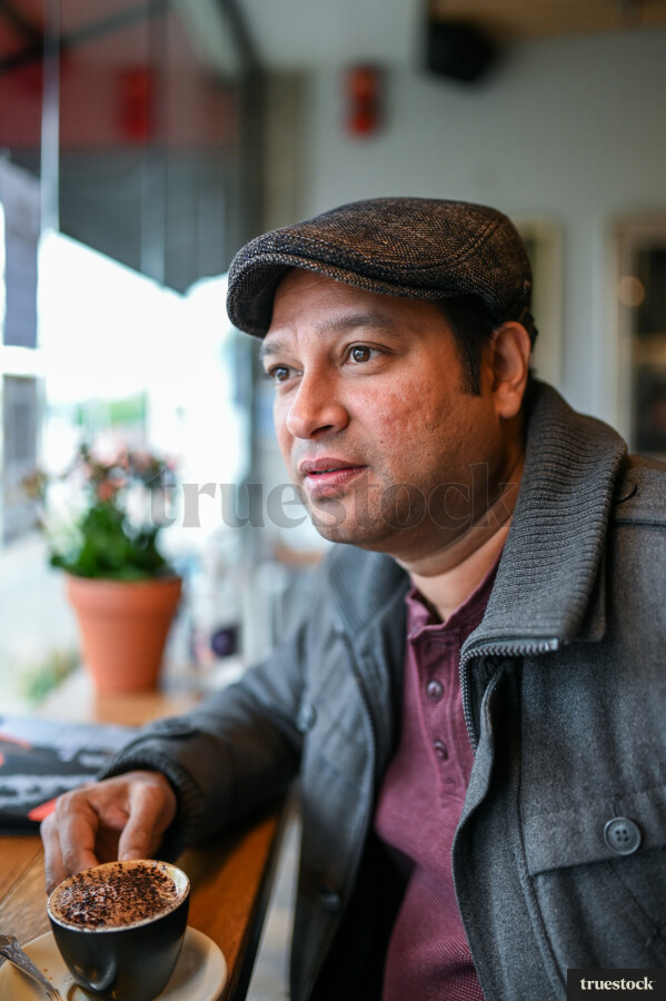 Adult male in a cafe drinking a coffee