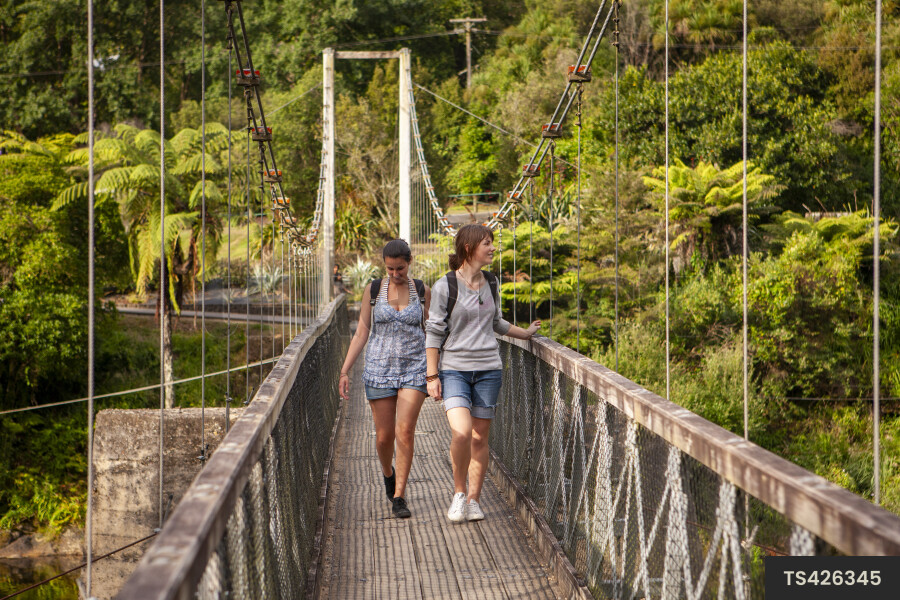 Teenage girls hiking on bridge in Karangahake Gorge