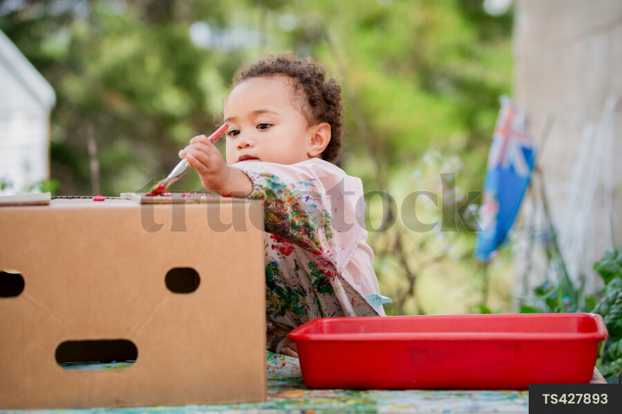 Baby girl doing arts and crafts outside in garden