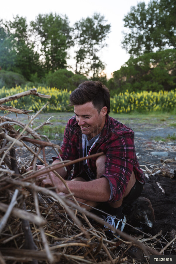 Man building campfire on beach