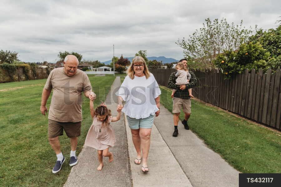 Young Girl With Grandparents on Walk