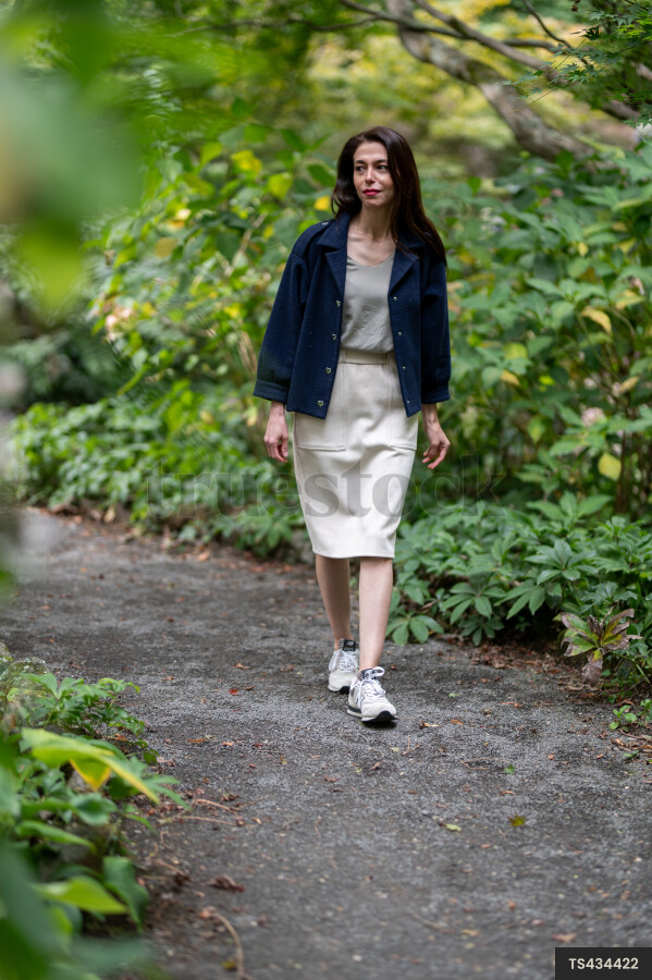 Woman with blue jacket walking in park
