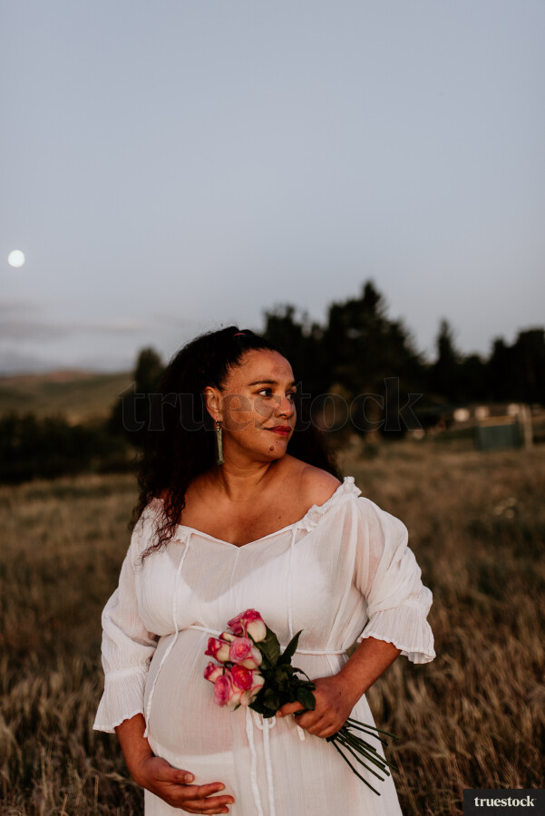 Woman Holding Flowers for Maternity Shoot