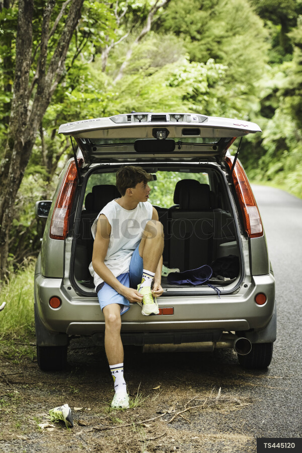 Teen Boy Putting on Sneakers
