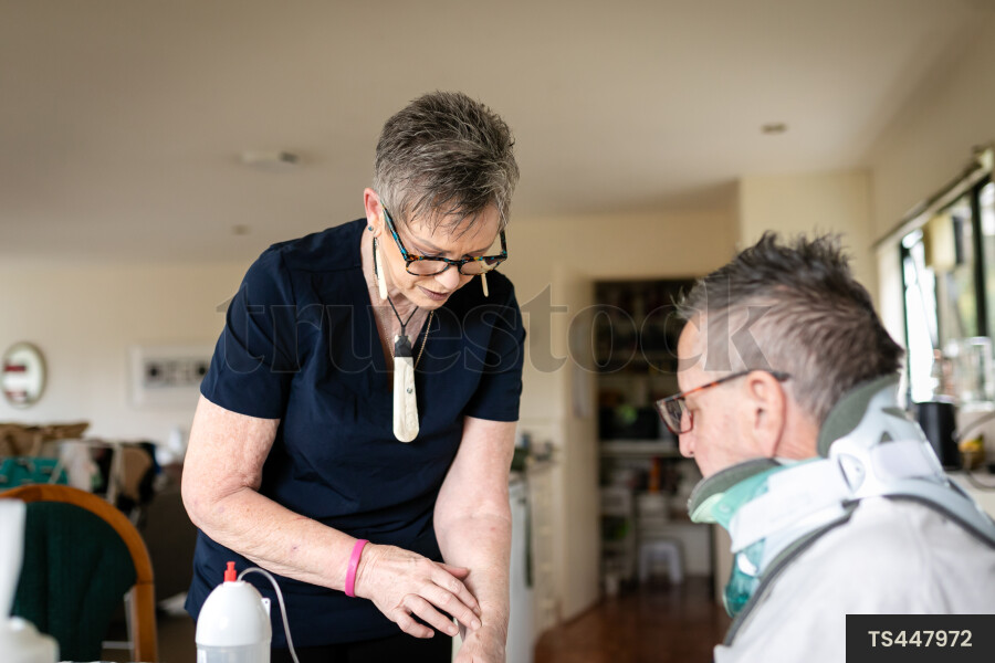 Health carer giving medicine to patient with neck brace