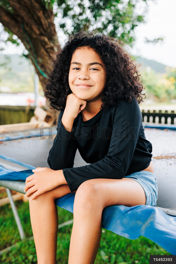 Young Girl Sitting On Trampoline