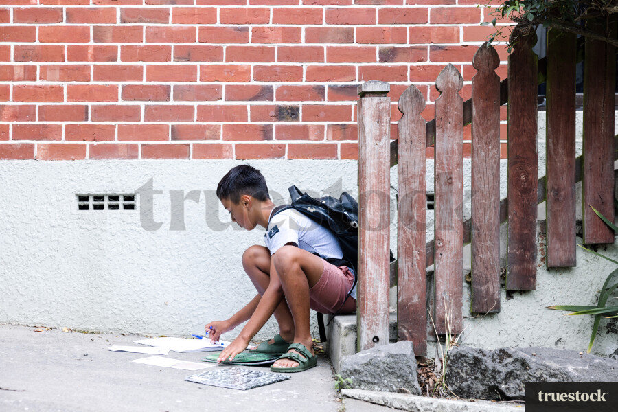 Young Boy Doing Homework on Steps