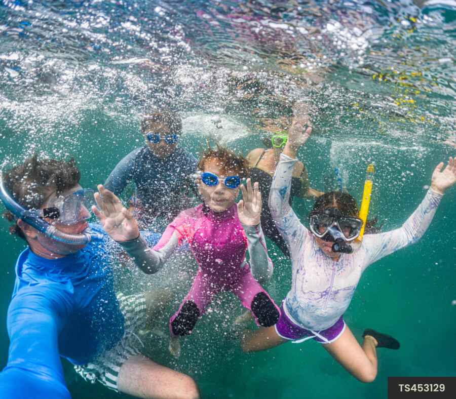 Family scuba diving underwater in sea