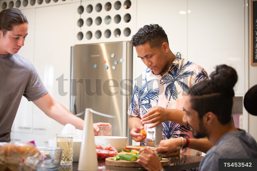 Men making salad in kitchen
