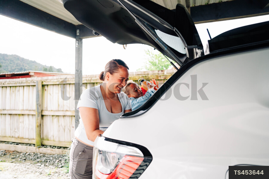 Woman and her daughter packing car