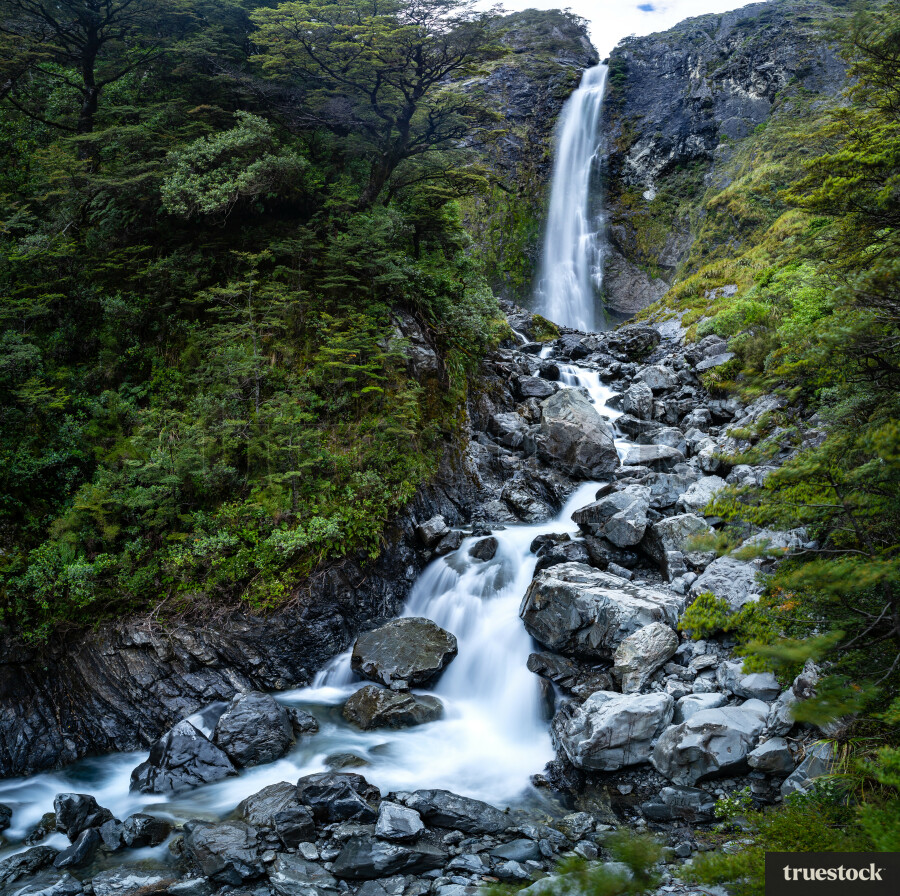 Waterfall down the cliff in the forest