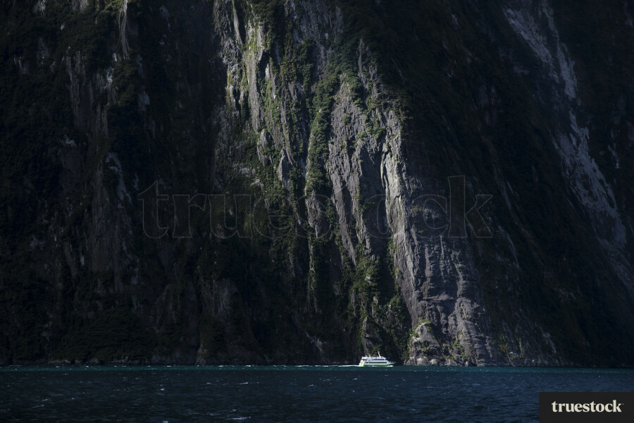 Boat Drawfed by Rock Face, Milford Sound