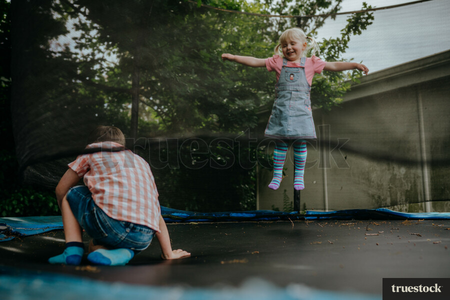 Brother and sister playing on a trampoline