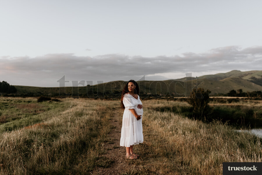 Woman Standing in Field for Maternity Shoot