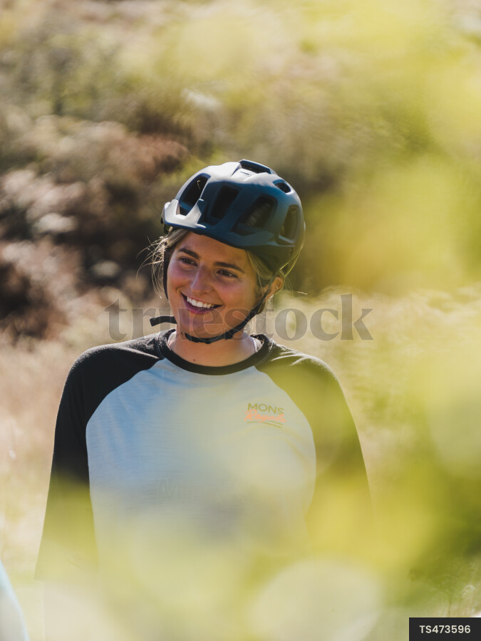 Woman with safety helmet smiling in native bush