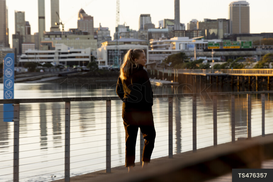 Woman walking on boardwalk by waterfront