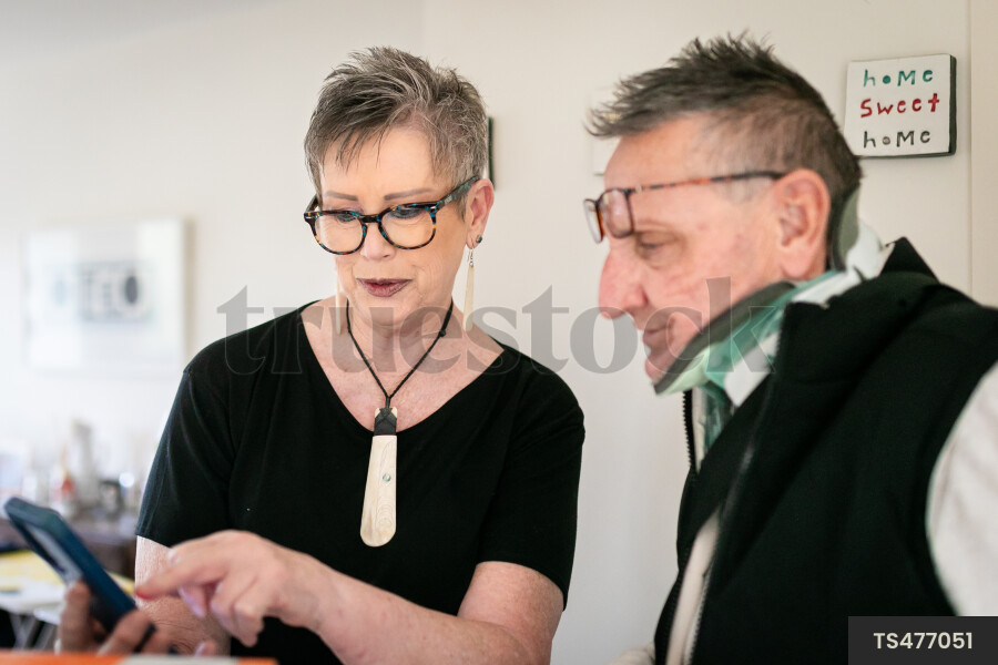 Health carer showing smart phone to patient
