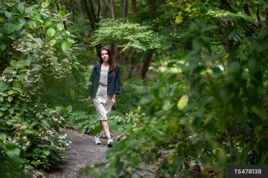 Woman with blue jacket walking in park