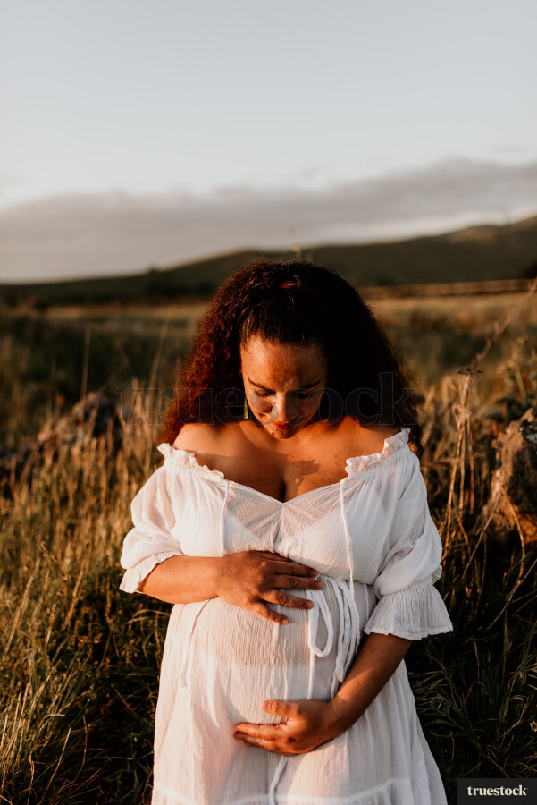 Woman Standing in Field for Maternity Shoot