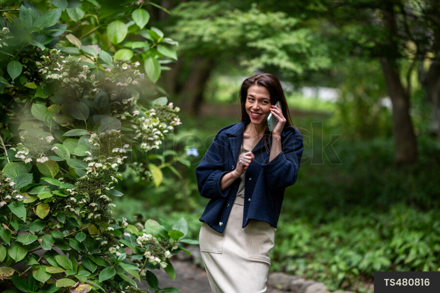 Young woman with smart phone in park