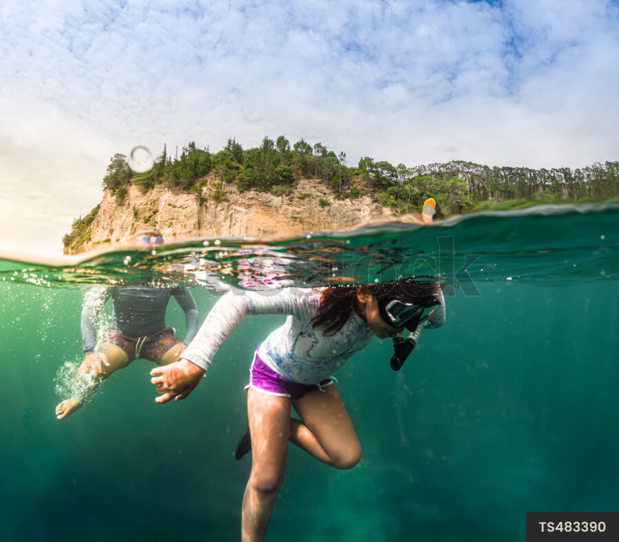 Brother and sister scuba diving in sea