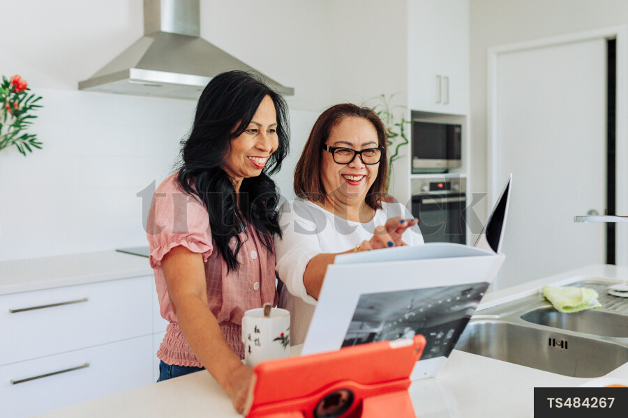 Women Using Device in Kitchen