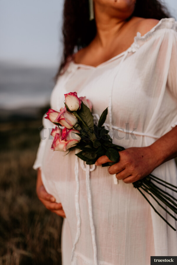 Woman Holding Flowers for Maternity Shoot