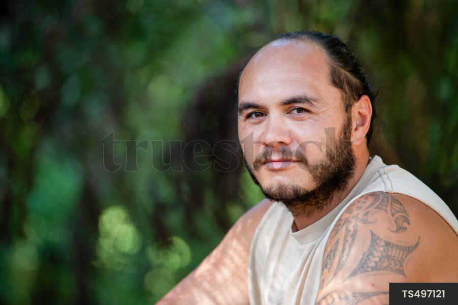 Portrait of Maori man with moko tattoo in garden
