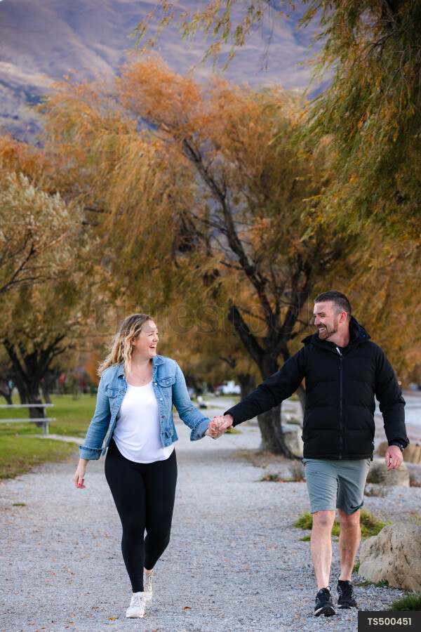 Couple holding hands while walking in park