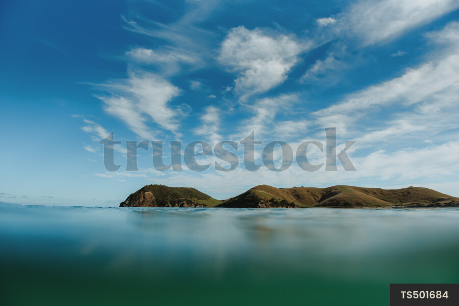Seascape by coastline under cloud