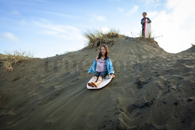 Kids on Boogie Board Down Sand Bank